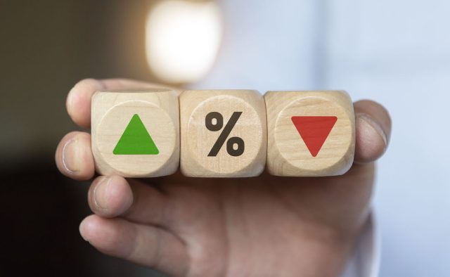 business man Hand change wood cube block with percentage to UP and Down arrow symbol icon. Interest rate, stocks, financial, ranking, mortgage rates and Cut loss concept